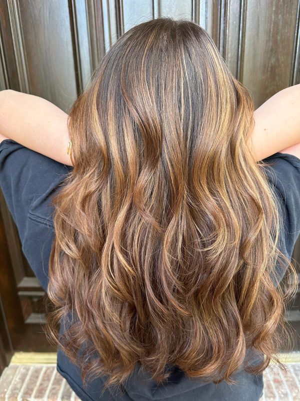 hair styling — warm caramel highlights with soft waves